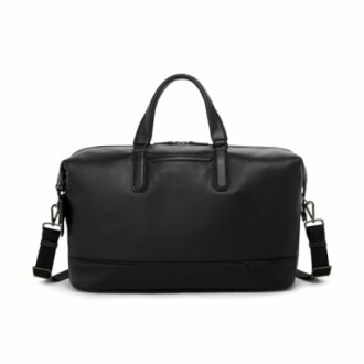 Black leather duffel bag with handles and shoulder strap.