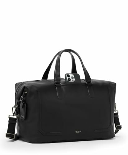 Black leather weekender bag with smartphone in pocket.