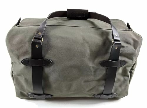 Green duffle bag with leather straps.