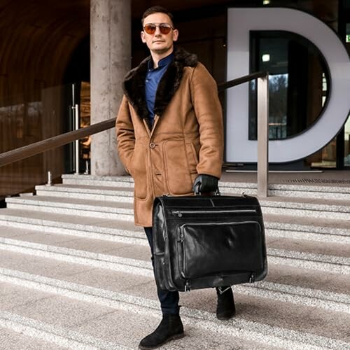 Man in sunglasses and coat holding a large briefcase on steps.